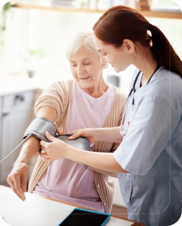 Nurse checking blood pressure of a senior woman at home