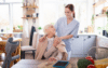 Caregiver smiling at elderly woman in cozy kitchen setting