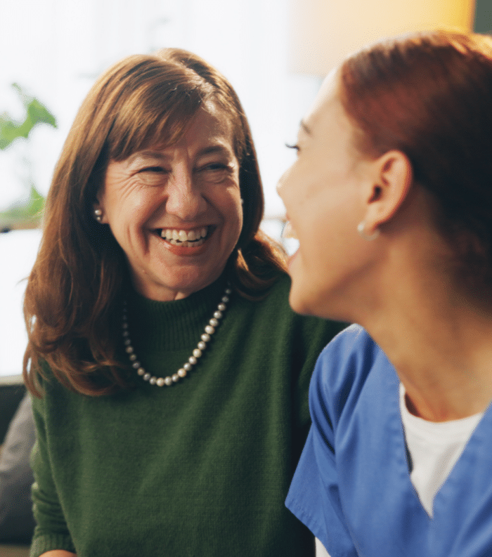 Senior Woman And Nurse With Talking Or Laughing O 2026 01 09 09 43 33 Utc 1 E1770119927143 Older woman and young nurse share a joyful conversation indoors